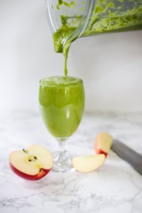 green pineapple apple smoothie in glass. Poured from blender