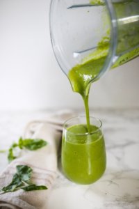 Pouring green smoothie from blender
